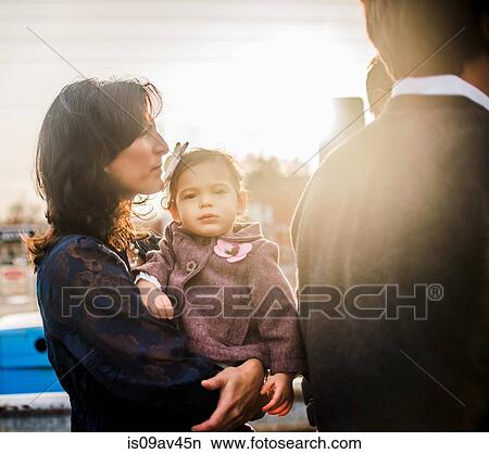 Picture - Mature woman holding young daughter, outdoors. Fotosearch
