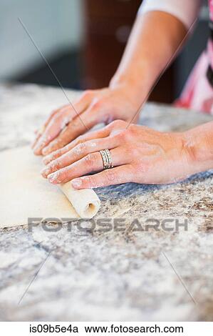 Stock Image - Mature woman making home made pasta, close-up. Fotosearch