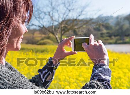 Mature woman outdoors, in rural setting, taking picture using smartphone View Large Photo Image Stock Photograph - Mature woman outdoors, in rural setting, taking picture using smartphone. Fotosearch