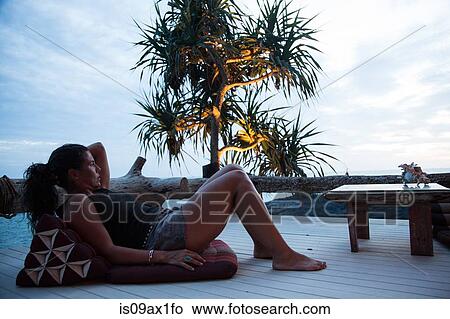 Mature woman relaxing on decking, looking at view, at dusk, Koh Lanta, Thailand View Large Photo Image Picture - Mature woman relaxing on decking, looking at view, at dusk, Koh Lanta, Thailand. Fotosearch