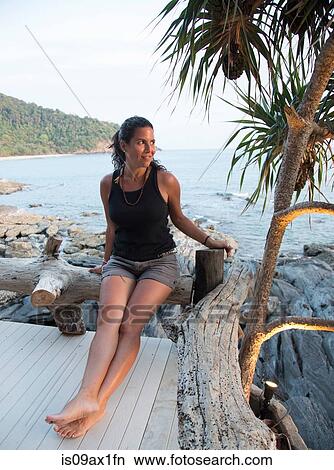 Mature woman sitting on decking, looking at view, Koh Lanta, Thailand View Large Photo Image Picture - Mature woman sitting on decking, looking at view, Koh Lanta, Thailand. Fotosearch