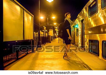 Mature woman standing on train platform at night View Large Photo Image Stock Image - Mature woman standing on train platform at night. Fotosearch