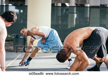 Men on basketball court bending over sideways touching toes smiling View Large Photo Image Stock Image - Men on basketball court bending over sideways touching toes smiling. Fotosearch
