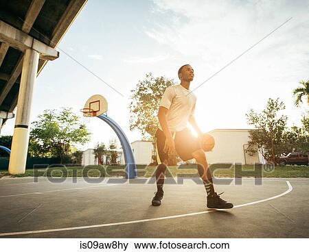 Men on basketball court holding basketball looking away View Large Photo Image Stock Photo - Men on basketball court holding basketball looking away. Fotosearch