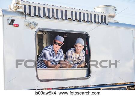 Men wearing chefs hats looking out of catering van hatch View Large Photo Image Picture - Men wearing chefs hats looking out of catering van hatch. Fotosearch