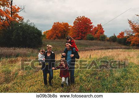 Mid adult family with three daughters strolling together in rural field View Large Photo Image Stock Photograph - Mid adult family with three daughters strolling together in rural field. Fotosearch