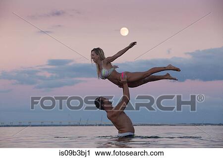 Mid adult man holding up girlfriend from sea at dusk, Santa Rosa Beach, Florida, USA View Large Photo Image Stock Image - Mid adult man holding up girlfriend from sea at dusk, Santa Rosa Beach, Florida, USA. Fotosearch