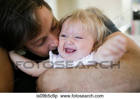 Mid adult man hugging baby daughter View Large Photo Image Stock Photography - Mid adult man hugging baby daughter. Fotosearch