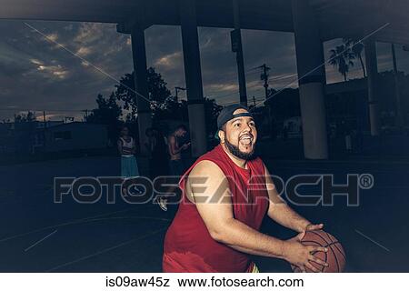 Mid adult man wearing vest playing basketball open mouthed smiling View Large Photo Image Stock Photo - Mid adult man wearing vest playing basketball open mouthed smiling. Fotosearch