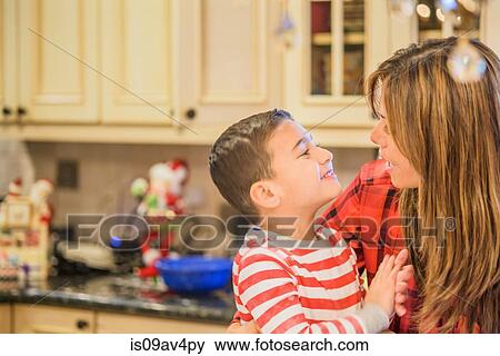 Mid adult woman and cute son in kitchen View Large Photo Image Stock Photo - Mid adult woman and cute son in kitchen. Fotosearch
