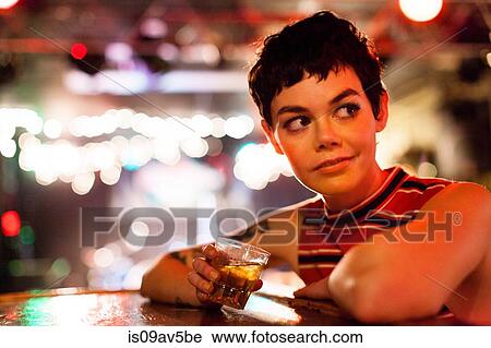 Mid adult woman drinking alcoholic drink View Large Photo Image Stock Image - Mid adult woman drinking alcoholic drink. Fotosearch