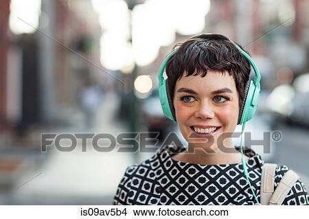 Mid adult woman, retro clothing, wearing headphones, outdoors View Large Photo Image Picture - Mid adult woman, retro clothing, wearing headphones, outdoors. Fotosearch