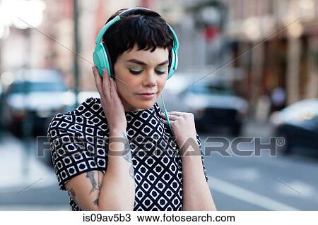 Mid adult woman, retro clothing, wearing headphones, outdoors View Large Photo Image Stock Image - Mid adult woman, retro clothing, wearing headphones, outdoors. Fotosearch