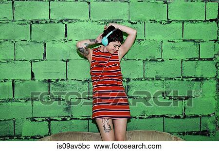 Mid adult woman with tattoos, wearing headphones, dancing View Large Photo Image Stock Image - Mid adult woman with tattoos, wearing headphones, dancing. Fotosearch