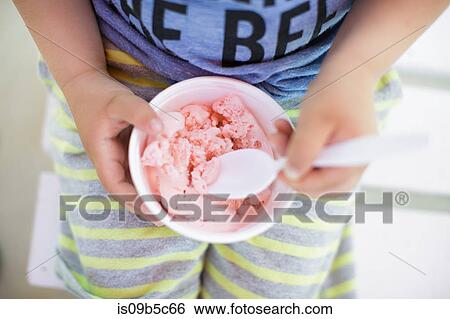 Mid section of boy eating bowl of pink ice cream View Large Photo Image Stock Photograph - Mid section of boy eating bowl of pink ice cream. Fotosearch