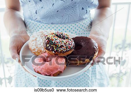 Mid section of woman holding plate of doughnut holes View Large Photo Image Stock Image - Mid section of woman holding plate of doughnut holes. Fotosearch