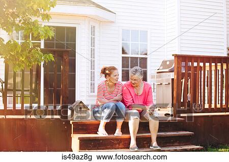 Mother and adult daughter sitting on porch View Large Photo Image Stock Image - Mother and adult daughter sitting on porch. Fotosearch