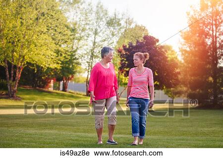 Mother and adult daughter walking in rural setting, at sunset View Large Photo Image Stock Image - Mother and adult daughter walking in rural setting, at sunset. Fotosearch
