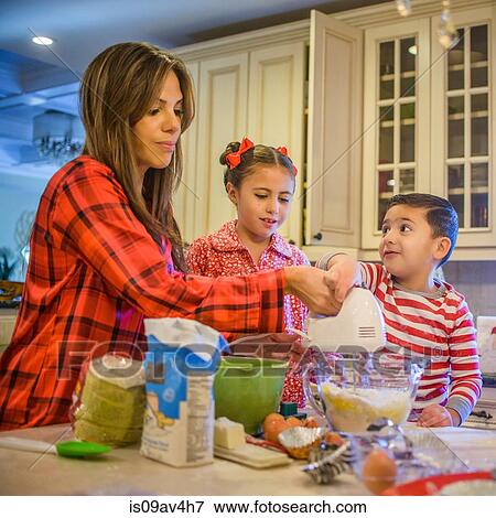 Mother and children in kitchen, using hand whisk View Large Photo Image Stock Photo - Mother and children in kitchen, using hand whisk. Fotosearch