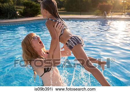 Mother and daughter in swimming pool, mother lifting daughter View Large Photo Image Stock Image - Mother and daughter in swimming pool, mother lifting daughter. Fotosearch