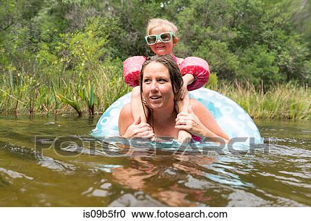 Stock Image - Mother and daughter with inflatable ring in lake, Niceville, Florida, USA. Fotosearch