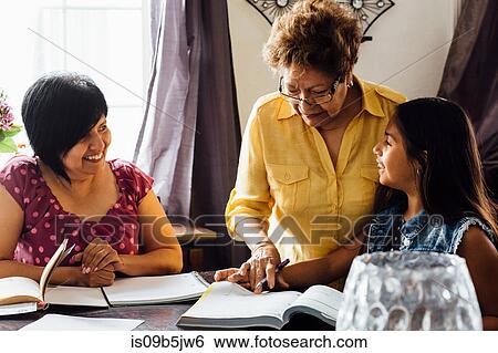 Stock Photograph - Mother and grandmother helping girl with homework. Fotosearch