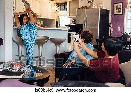 Mother and grandmother photographing girl standing on one leg, doing splits View Large Photo Image Stock Image - Mother and grandmother photographing girl standing on one leg, doing splits. Fotosearch