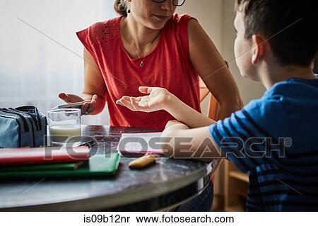 Mother and son at dining table having discussion View Large Photo Image Stock Photography - Mother and son at dining table having discussion. Fotosearch