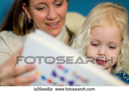 Mother and young daughter looking at book together View Large Photo Image Stock Photo - Mother and young daughter looking at book together. Fotosearch