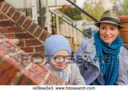 Stock Image - Mother and young son sitting together on front steps. Fotosearch