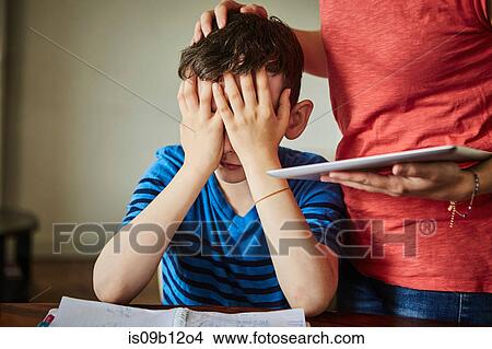 Picture - Mother comforting upset son doing homework. Fotosearch