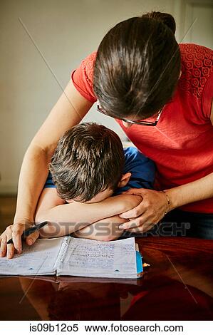 Mother comforting upset son doing homework View Large Photo Image Stock Photography - Mother comforting upset son doing homework. Fotosearch