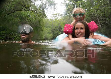 Mother, father and daughter with inflatable ring in lake, Niceville, Florida, USA View Large Photo Image Stock Image - Mother, father and daughter with inflatable ring in lake, Niceville, Florida, USA. Fotosearch