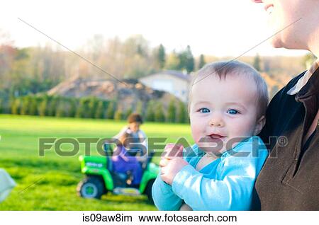 Mother holding baby girl, outdoors, mid section View Large Photo Image Picture - Mother holding baby girl, outdoors, mid section. Fotosearch