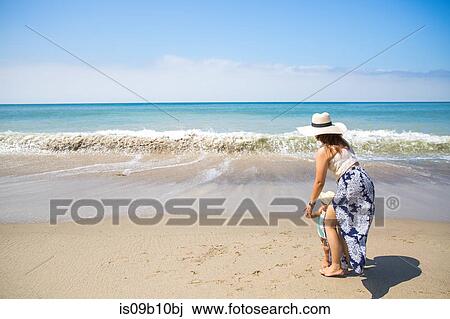 Mother holding hands with baby son on beach, Malibu, California, USA View Large Photo Image Stock Image - Mother holding hands with baby son on beach, Malibu, California, USA. Fotosearch
