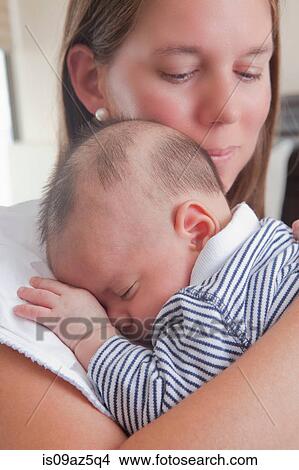 Mother holding sleeping baby boy View Large Photo Image Picture - Mother holding sleeping baby boy. Fotosearch