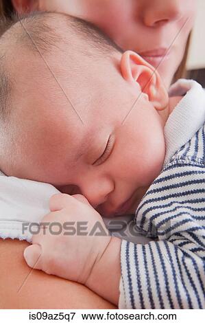 Mother holding sleeping baby boy View Large Photo Image Stock Photo - Mother holding sleeping baby boy. Fotosearch