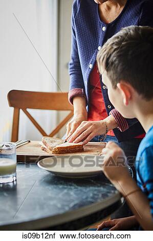 Stock Image - Mother making son sandwich. Fotosearch