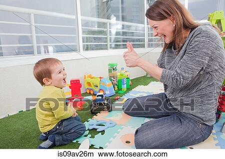 Mother playing with son at home View Large Photo Image Picture - Mother playing with son at home. Fotosearch