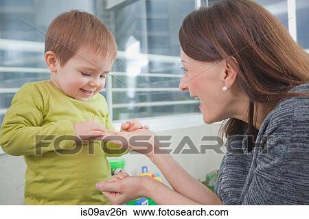 Mother playing with son at home View Large Photo Image Picture - Mother playing with son at home. Fotosearch