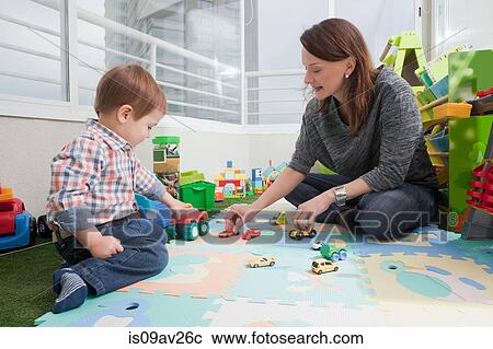 Stock Image - Mother playing with son at home. Fotosearch