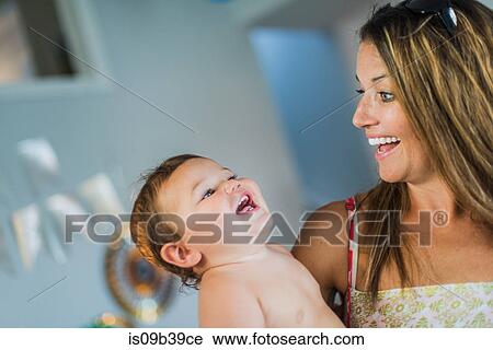 Stock Image - Mother playing with toddler in arms. Fotosearch