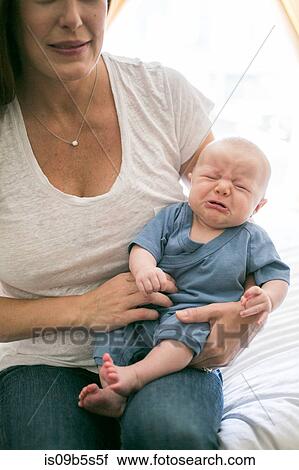 Mother sitting with crying baby boy View Large Photo Image Stock Image - Mother sitting with crying baby boy. Fotosearch
