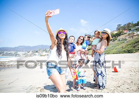 Mother taking selfie of friends and babies on beach, Malibu, California, USA View Large Photo Image Picture - Mother taking selfie of friends and babies on beach, Malibu, California, USA. Fotosearch