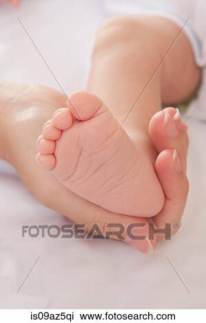 Mothers hand holding baby boys foot View Large Photo Image Stock Image - Mothers hand holding baby boys foot. Fotosearch