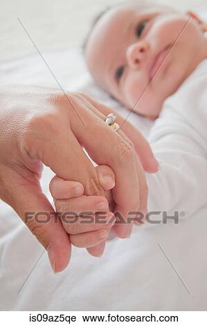 Mothers hand holding baby boys hand View Large Photo Image Stock Image - Mothers hand holding baby boys hand. Fotosearch