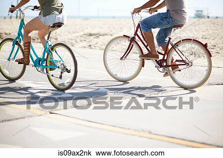 Neck down view of couple cycling at Venice Beach, Los Angeles, California, USA View Large Photo Image Stock Image - Neck down view of couple cycling at Venice Beach, Los Angeles, California, USA. Fotosearch