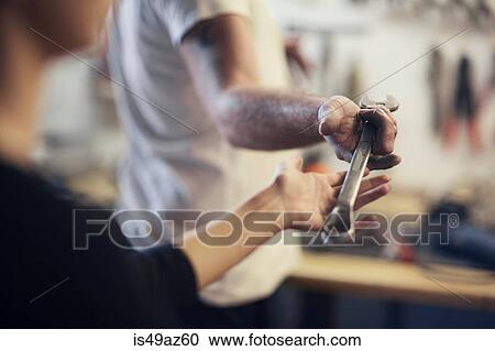 Over shoulder view of man handing wrench in boat repair workshop View Large Photo Image Stock Image - Over shoulder view of man handing wrench in boat repair workshop. Fotosearch