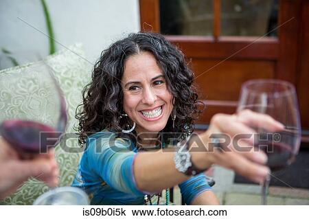 Over shoulder view of mature women making red wine toast at garden party View Large Photo Image Stock Image - Over shoulder view of mature women making red wine toast at garden party. Fotosearch