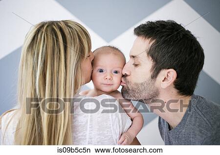 Over shoulder view of mid adult couple kissing baby son on cheek View Large Photo Image Picture - Over shoulder view of mid adult couple kissing baby son on cheek. Fotosearch